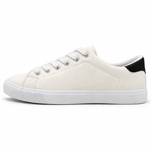 Side profile of warm off-white low-top sneaker with black heel patch.