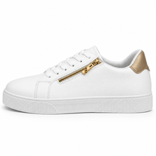 White low-top sneaker outer side with gold-tone zipper and metallic gold heel patch.